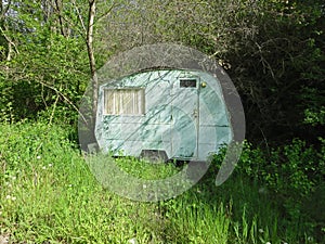 Small old caravan in the woods. Arcadian vacation in the nature. photo