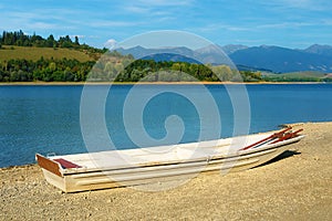 Small old fishing boat on a lake shore. Lake background.