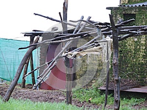 Small old house supported by wooden logs in a village in India - rural India scene