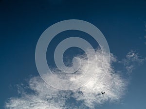 Small one engine air plane flying through clouds high in the sky