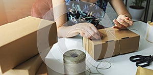 Small online business owner packing parcel box at home to deliver product to customer. banner