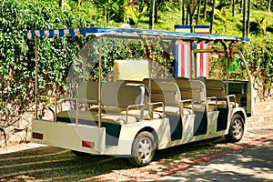 A small open bus for transporting tourists in Nanshan Park. Sanya, Hainan.