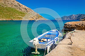 Small open-deck motor boat in Greek colors in port at the bay of