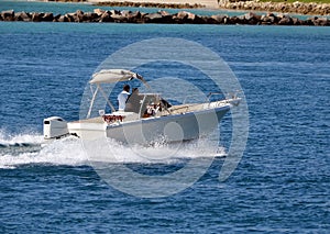 Small open fishing boat powered by a single outboard engine