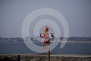 Small orange lighthouse on Esbjerg harbor in Denmark