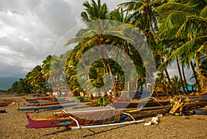 A small outrigger style Banca boat rests on a tropical beach.Pandan, Panay, Philippines.