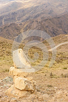 Small painted stone sculpture, located on the top of the hills in the afternoon in Shupluy - Peru