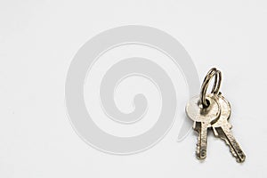 Small pair of silver keys on a white background