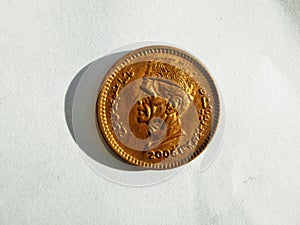 Small Pakistani One rupee bronze coin on white