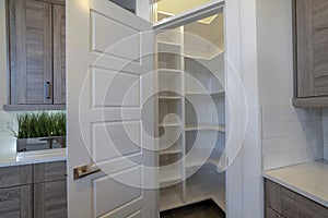 Small pantry with empty wall shelves at the corner of the kitchen of home