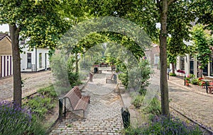 Small park with wooden benches in the Dutch village of Drimmelen