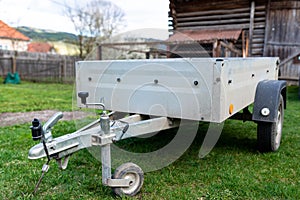 Small, parked luggage trailer on green grass