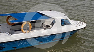 Small passenger motor boat with nobody inside docking, parking or floating in the water