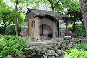 A small pavilion in a Japanese Garden filled with ferns, plants, shrubs and trees in Janesville, Wisconsin