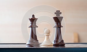 Small pawn on chess board against larger adversary concept of adversity ,discimination ,equality photo