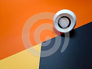 small pc white speaker on yellow withe orange and black background isolated