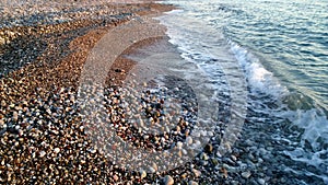 A small pebble on the shore of the sea and the beautiful runaway wave