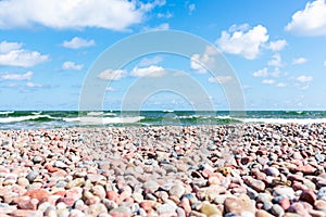 Small pebbles on the shore. sunny summer day blue sky,white clouds. beautiful lonely pebble beach.Copy space