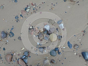 Small pebbles and stones amongst the wet sand of a North of Scotland beach