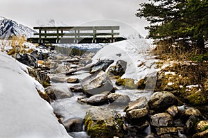 Small pedestrian bridge over a creek on a winter day