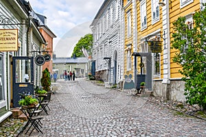 A small, picturesque, and colorful cobblestone street of shops and cafes in the medieval village of Porvoo, Finland