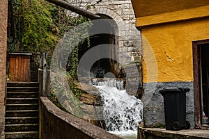 Small picturesque waterfall cascading  underneath a bridge in Hallstatt, Austria