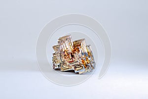 A small piece of natural bismuth on a white background