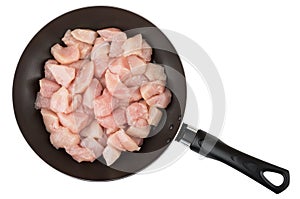 Small pieces of raw chicken meat in frying pan