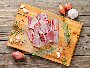 Small pieces of raw lamb ribs on wooden chopping Board on old ru