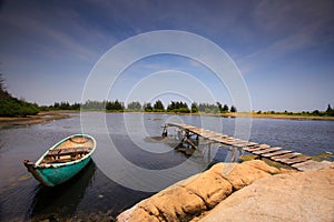 Small pier with boat in a pond