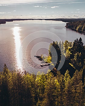 Small pier at the shore of a big lake on a evening with sun reflecting in the water photo