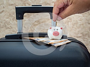 Small piggy bank on a suitcase. The concept of saving money to relax and travel.
