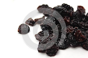 Small pile of black raisins on a white backgr