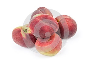 Pile of flat and ordinary peaches on a white background