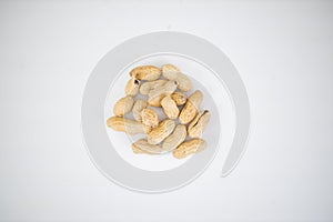 Small pile of peanuts in shell isolated on white table