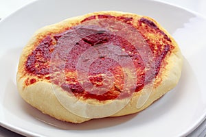 Small pizza (pizzette) on plate photo