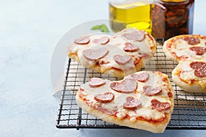 Small pizzas with mozzarella cheese, pepperoni, tomato and basil