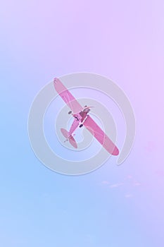 Small plane flying against the blue, purple, pink sky