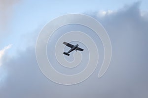 Small plane flying on the backgorund of clouds.