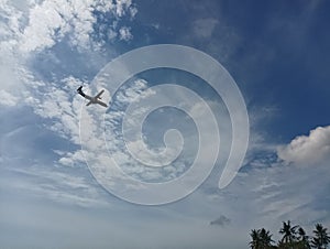 A Small Plane Flying Through a Blue Sky with White Clouds