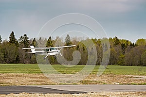 Small plane stands on the runway against the background of the forest