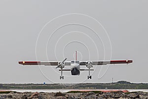 A small plane takes off and takes off on the island of Dune. Background is bright sky photo