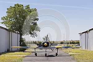 Small plane between two rows of hangars