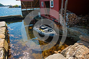 Small plastic boat boored by a boat house..