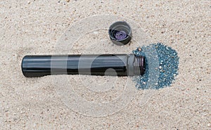 A small plastic bottle in the sand on the beach