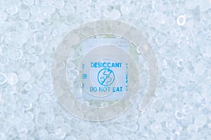 Small plastic container that contains silica gel crystals. It is a desiccant