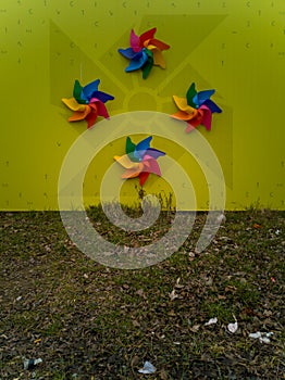 Small plastic windmills as decoration of fence near street