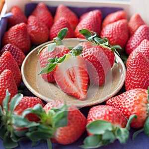 Small plate filled with succulent juicy fresh ripe red strawberr