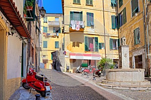 Small plaza among colorful houses in Ventimiglia, Italy.