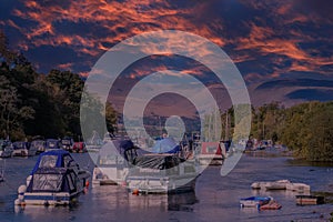 Small Pleasure Craft at the bottom of Loch Lomond in Balloch at the Sunset end of the day with a Blazing red Dramatic sky